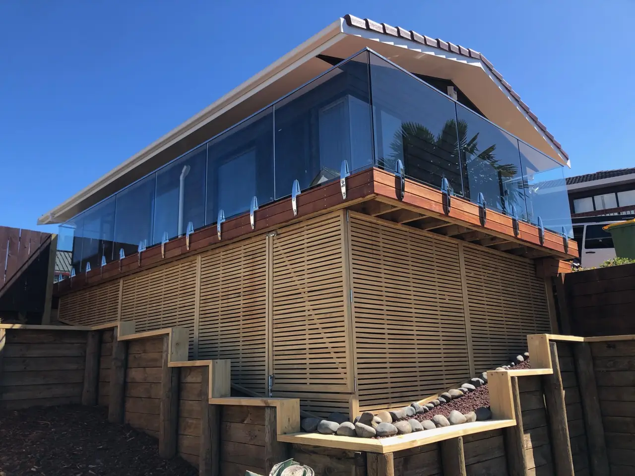 Glass balustrade deck with batten screening by Custom Decks and Fences